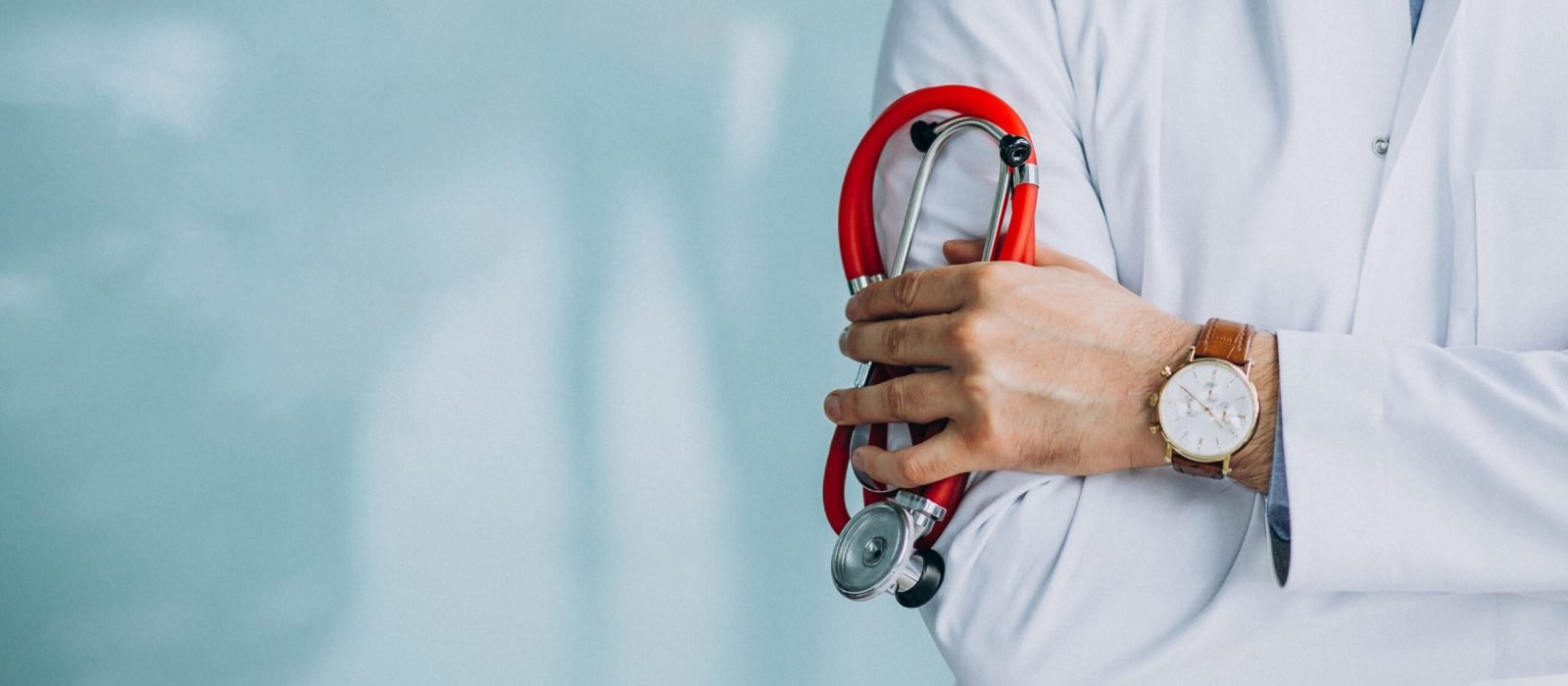 Young handsome physician in a medical robe with stethoscope